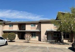 El Paso apartment for rent - A white car is parked in front of a beige building.