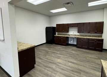 El Paso apartment for rent - A kitchen area with brown cabinets and a black refrigerator.