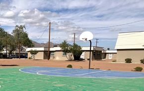 El Paso apartment for rent - A basketball court with a basketball hoop and a building in the background.