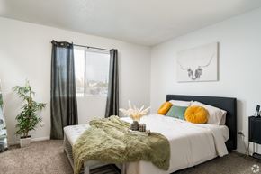 El Paso apartment for rent - A bedroom with a large bed and a green blanket.