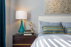 Summerville apartment for rent - A bedroom with a white bed and a blue lamp.