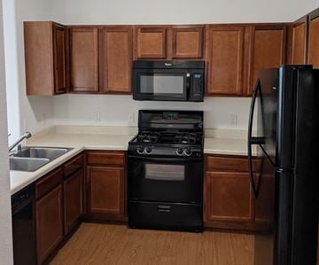 El Paso apartment for rent - A kitchen with brown cabinets and black appliances.