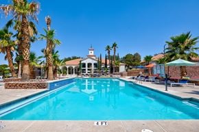 El Paso apartment for rent - a swimming pool with palm trees and a building in the background