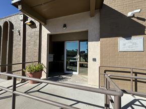 El Paso apartment for rent - A building entrance with a sign and a potted plant.
