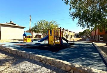 El Paso apartment for rent - A playground with a yellow slide and a blue roofed building.