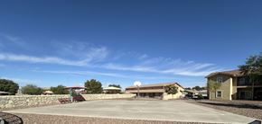El Paso apartment for rent - A basketball court is surrounded by a stone wall and buildings.