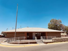 El Paso apartment for rent - A small building with a brown roof and a stone wall in front.