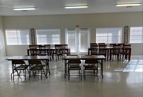 El Paso apartment for rent - A room with tables and chairs and an exit sign.