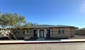 El Paso apartment for rent - A small house with a brown roof and a white door is surrounded by a gravel driveway.
