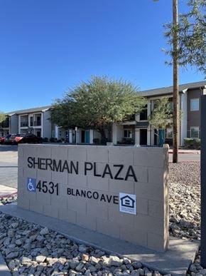 El Paso apartment for rent - A sign for Sherman Plaza stands in front of a building.