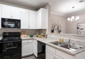 El Paso apartment for rent - A kitchen with black appliances and white cabinets.