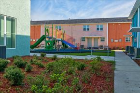 Jacksonville apartment for rent - A playground with a green slide and red mulch in the foreground.