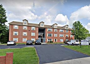 Louisville apartment for rent - a large brick building with cars parked in front of it
