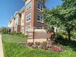 St. Louis apartment for rent - A brick building with a sign that says "Woodhurst Village" in front of it.
