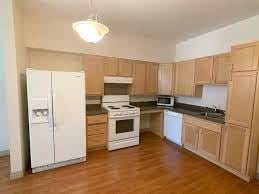 St. Louis apartment for rent - A kitchen with wooden cabinets and white appliances.