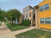 St. Louis apartment for rent - A yellow building with a brown door and windows.