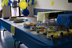 Louisville apartment for rent - Community event setup with tables of food, balloons, and decorations in a blue and yellow theme