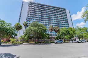 St. Petersburg apartment for rent - an empty parking lot in front of a tall building with palm trees