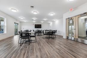 St. Louis apartment for rent - a conference room with tables and chairs and a tv on the wall