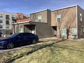St. Louis apartment for rent - A blue car is parked in front of a modern two-story building.