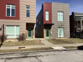St. Louis apartment for rent - A row of modern townhouses with green doors and windows.