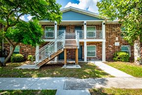 Jacksonville apartment for rent - A brick house with a blue roof and a white staircase.