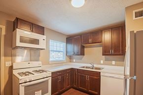 Jacksonville apartment for rent - A kitchen with brown cabinets and white appliances.