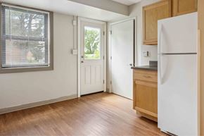 Rock Island apartment for rent - A kitchen with a white fridge and wooden floors.