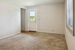 Rock Island apartment for rent - A room with a carpeted floor and a door leading outside.