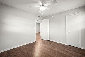 Jacksonville apartment for rent - A room with a ceiling fan and three doors.