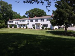Rock Island apartment for rent - A white building with a green lawn in front.