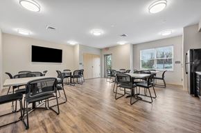St. Louis apartment for rent - a community room with tables and chairs and a tv