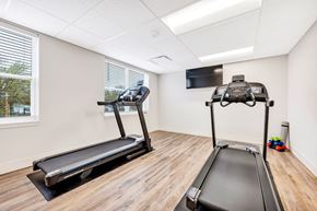 St. Louis apartment for rent - two treadmills and a television in a gym room