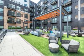 Edina apartment for rent - an outdoor lounge area with couches and tables in front of an apartment building
