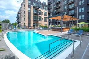 Edina apartment for rent - a swimming pool in front of an apartment building with a pool and chairs