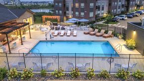Maple Grove apartment for rent - an aerial view of a swimming pool with lounge chairs at night