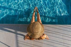 Edina apartment for rent - A woman in a straw hat is sitting on the edge of a pool.