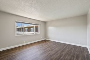 Alameda apartment for rent - A room with wooden floors and a window showing a view of a building outside.