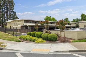 Fremont apartment for rent - a building with a black fence and a sidewalk in front of it