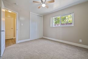 Livermore apartment for rent - A room with a ceiling fan and a window with a view of trees.