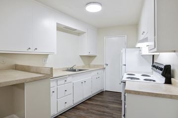 Fremont apartment for rent - A kitchen with white cabinets and a stove top oven.