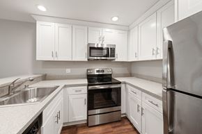 San Leandro apartment for rent - a kitchen with white cabinets and stainless steel appliances