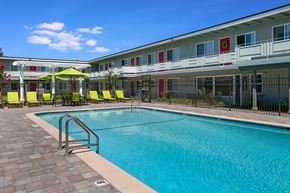 Castro Valley apartment for rent - A swimming pool in front of a building with a red umbrella.