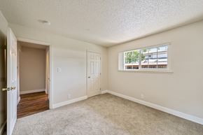Concord apartment for rent - A room with a carpeted floor and a window with a view of a building outside.