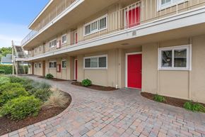 Fremont apartment for rent - A building with a red door and a brick pathway leading to it.