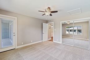 Fremont apartment for rent - A spacious room with a ceiling fan and sliding glass doors.