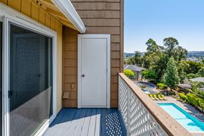 Castro Valley apartment for rent - A balcony with a white door and a pool in the background.