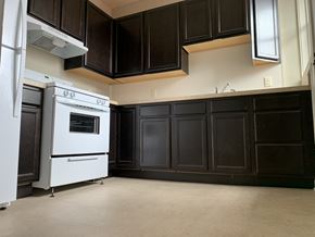 South Bend apartment for rent - a kitchen with black cabinets and a white stove and refrigerator