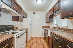Portsmouth apartment for rent - a kitchen with white appliances and brown cabinets