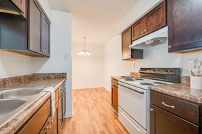 Portsmouth apartment for rent - a kitchen with white appliances and wood flooring and wooden cabinets